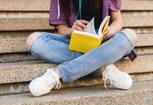 Έφηβη διαβάζει βιβλίο σε σκαλιά